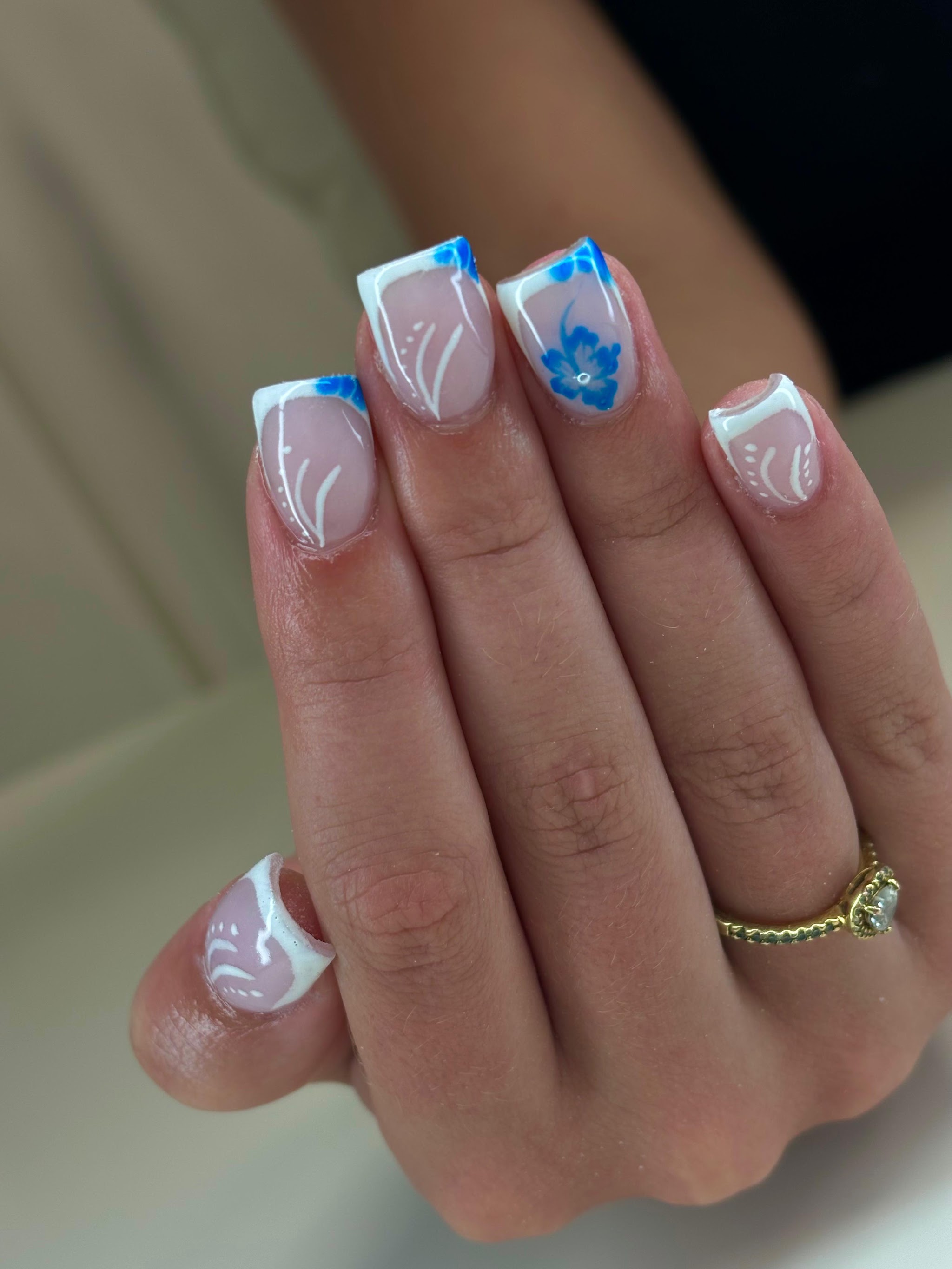 Witte french met blauwe bloemen op korte nagels