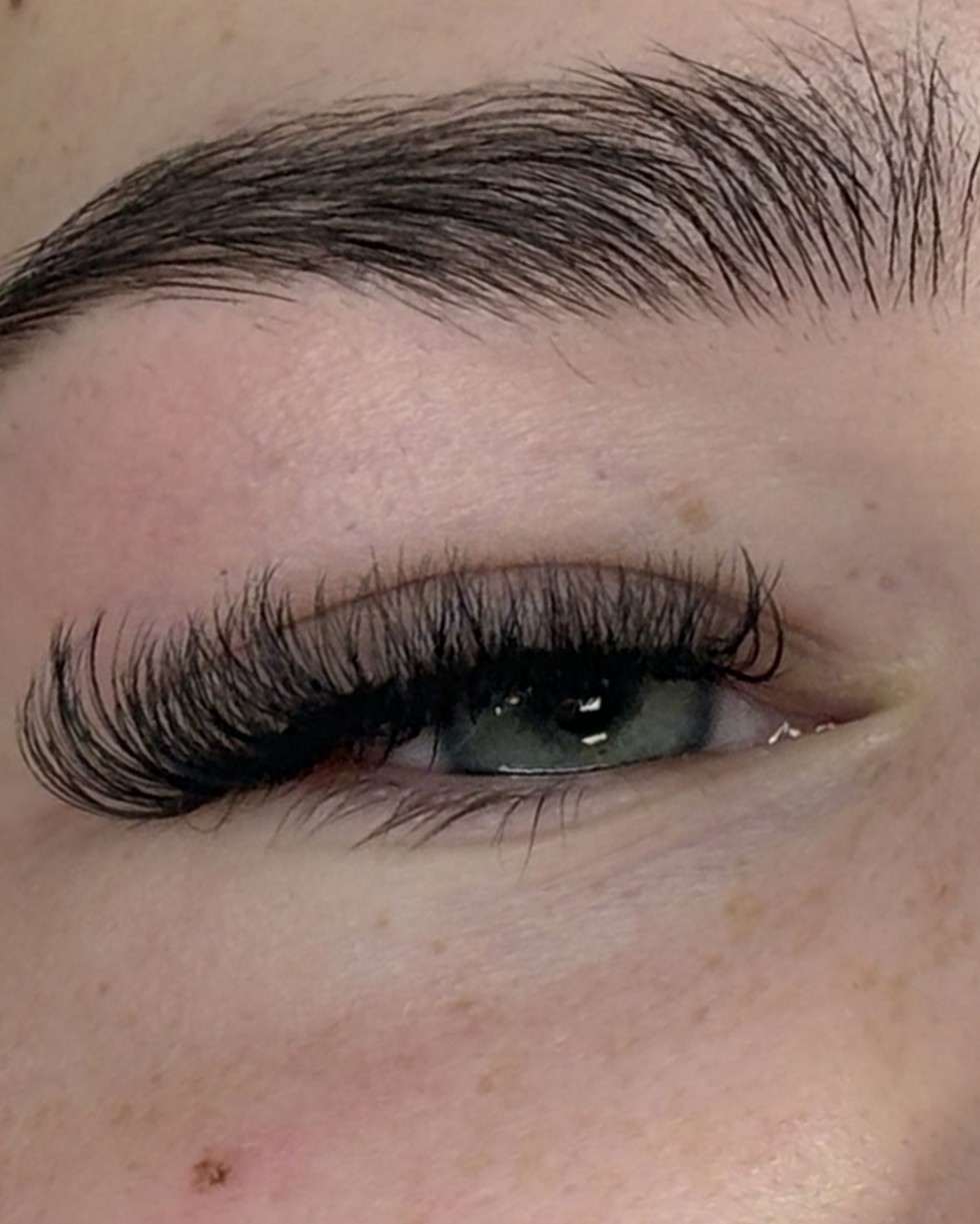 Close-up van een gelamineerde, volle wenkbrauw boven een oog met wimperextensions